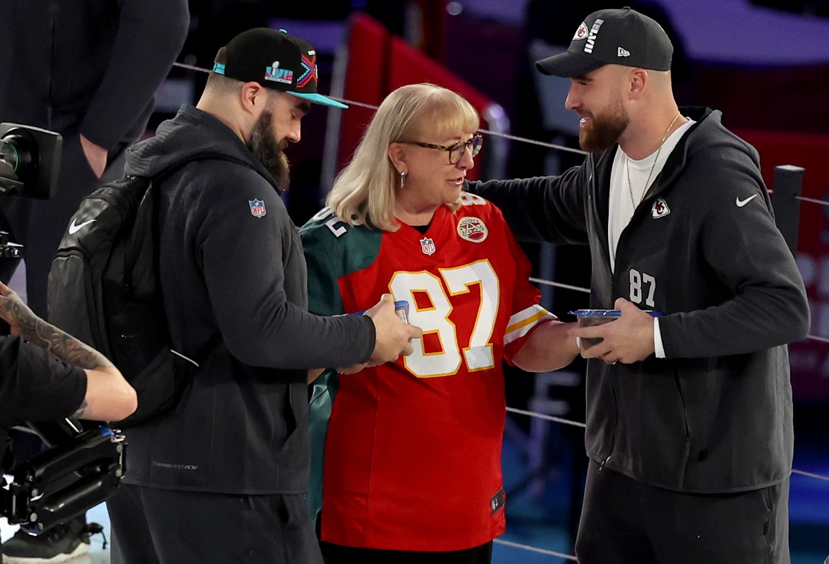 PHOENIX, ARIZONA - FEBRUARY 06: Mother Donna Kelce (C) gives cookies to her son's Jason Kelce (L) #6...