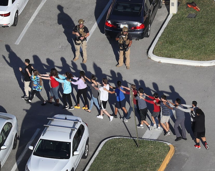 PARKLAND, FL - FEBRUARY 14: People are brought out of the Marjory Stoneman Douglas High School after...