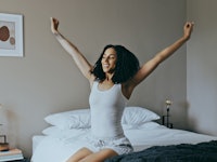 Wake up, black woman and stretching in bedroom, rest after sleeping and ready to start the new day. ...