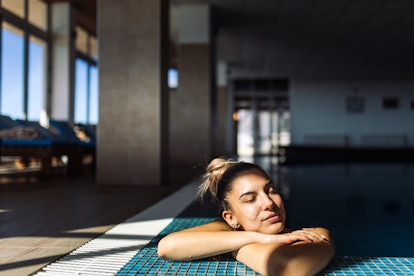 young woman relaxes in a pool as she considers how her zodiac sign affects her sleep