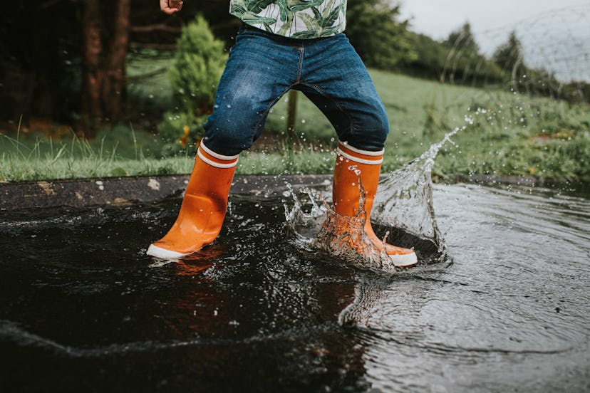 Child in bright orange rain boots jumps in ireland in a list of St Patricks Day names