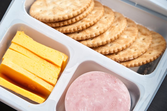 Plastic tray containing sliced honey ham,cheddar cheese, and crackers from above  