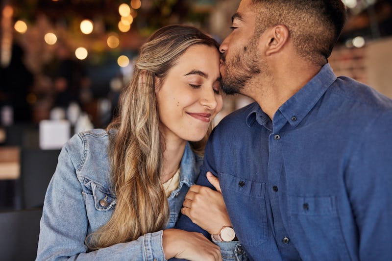 Couple, coffee shop and forehead kiss for love celebration, anniversary or congratulations for relat...