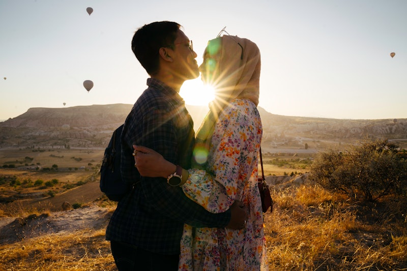 Portrait of a young muslim man kissing his wife in forehead during enjoy vacation in goreme