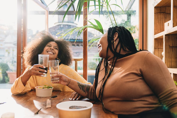 two young women have a toast as they discuss their april 2023 horoscope