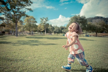 very happy girl laughing at the park.green lawn, blue sky.