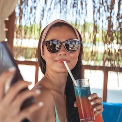 Woman taking selfie with mobile phone in summer vacation