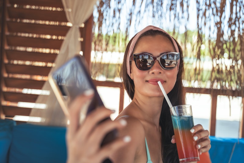 Woman taking selfie with mobile phone in summer vacation