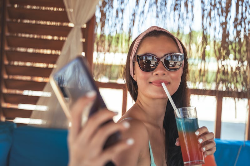 Woman taking selfie with mobile phone in summer vacation