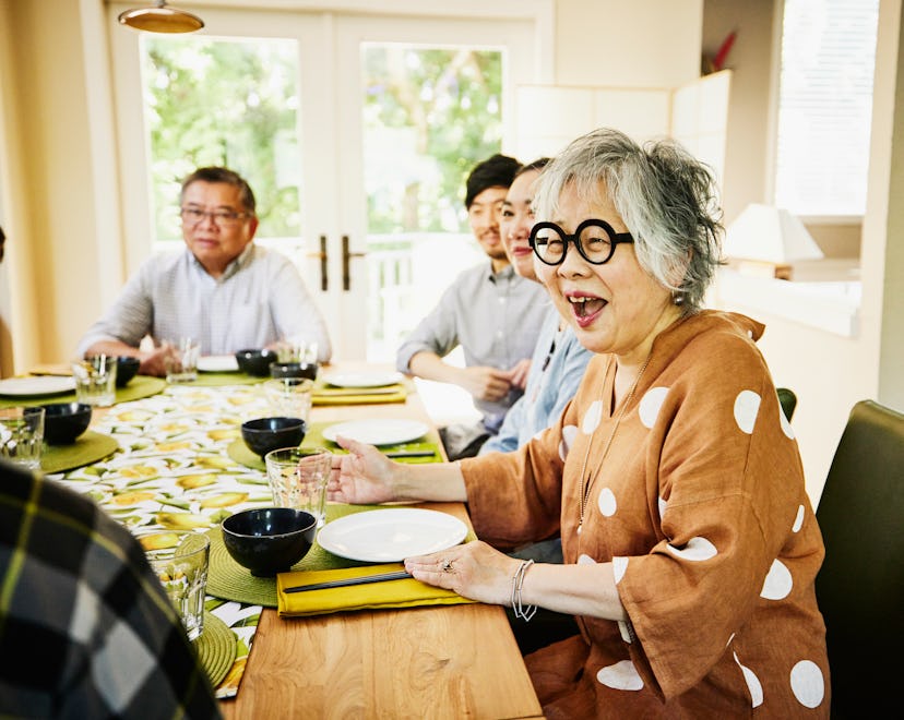 Laughing grandmother seated at dining room in an article about April Fools' Day pranks