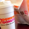 A cup of Dunkin' Donuts coffee and a donut bag sit on a counter September 7, 2006 in Chicago, Illino...
