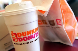 A cup of Dunkin' Donuts coffee and a donut bag sit on a counter September 7, 2006 in Chicago, Illino...