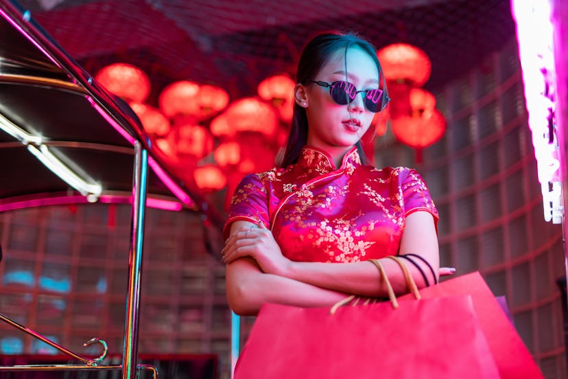 Portrait photo of a young asian female lady model wearing sunglasses in red Chinese traditional cheo...