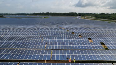 Aerial view of two engineer working in the solar power station farm in Thailand.