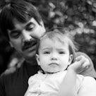 A black and white vintage photo of a dad with a thick mustache and his daughter.