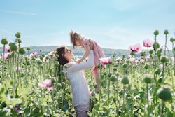 Mom and daughter play and enjoy nature in the poppy field