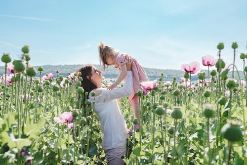 Mom and daughter play and enjoy nature in the poppy field