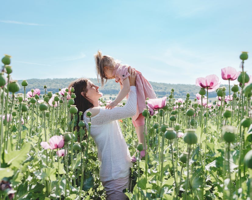 Mom and daughter play and enjoy nature in the poppy field