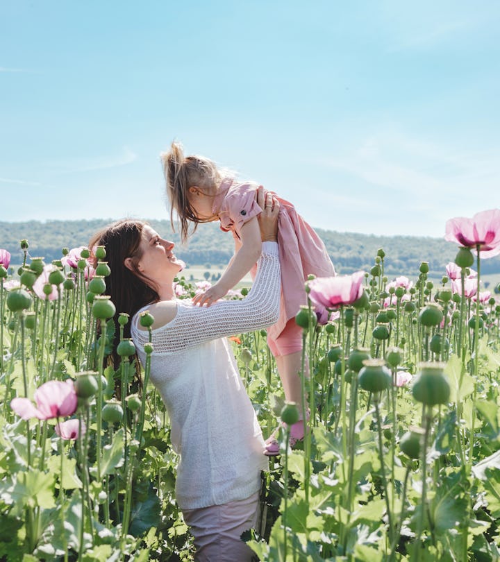 Mom and daughter play and enjoy nature in the poppy field