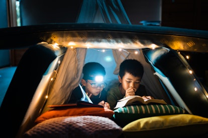 The two little boys studying , reading in home camp at night. in an article about is melatonin safe ...