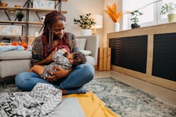 Mother breastfeeding her baby at home, in an article about how to stop breastfeeding