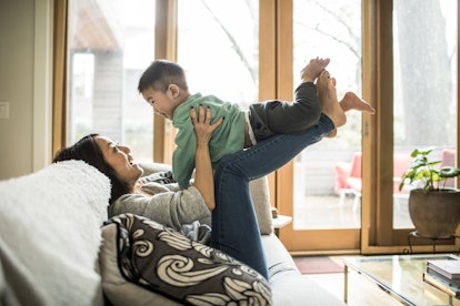 Mother playing with young son on couch at home, in a list of quotes about having sons.