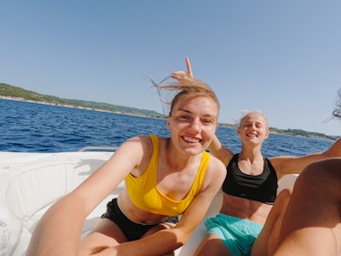 Smiling friends enjoying a summer day on a boat, representing the best Pisces qualities.