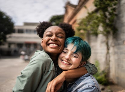 Two friends hugging and smiling, representing the 11th house in astrology, which determines how frie...