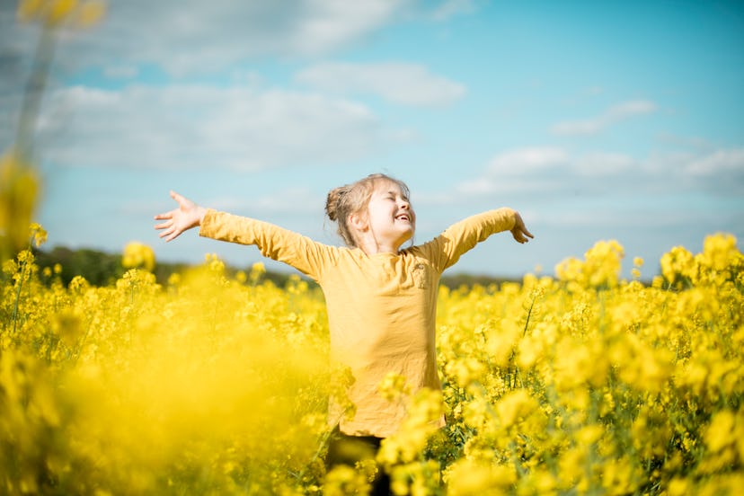 happy girl in yellow flower field in article about spring instagram captions