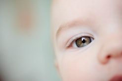 closeup of adorable baby with green eye in article about unique baby names for boys and girls