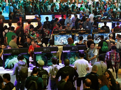 Gamers test new video games on display at the Sony Playstation area on the opening day of the Electr...
