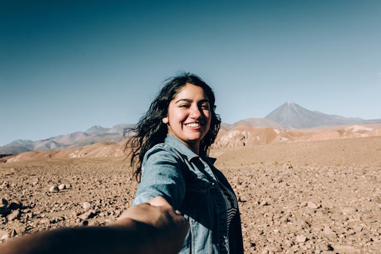 a young woman takes a selfie in the desert as she considers how the april 2023 hybrid solar eclipse ...