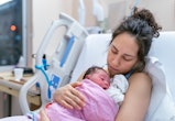 A mother is snuggling her newborn, in an article about postpartum cramps