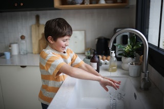 A boy washing his hands in the kitchen; According to new data, only 25% of parents actually believe ...