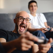Father and son playing video games together at home.