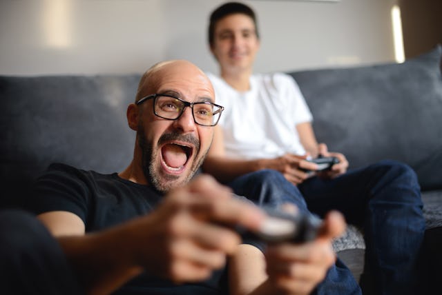 Father and son playing video games together at home.