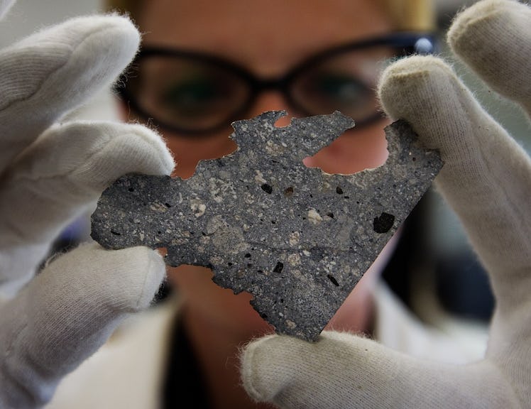 Katherine Dunnell, a technician in the Earth Sciences department at the ROM, inspects a slice of met...