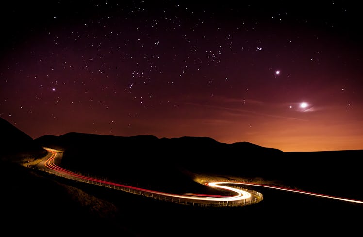 Light trails and stars cape with Venus, Jupiter, Orion and the moon clearly visible above a winding ...