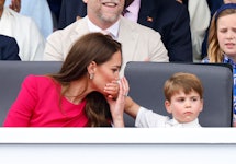 Prince Louis of Cambridge covers his mother Catherine, Duchess of Cambridge's mouth with his hand as...
