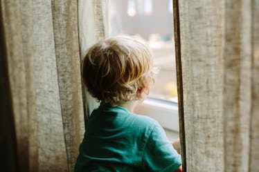 A toddler photographed from the back, between linen curtains. Kids sometimes need advocates outside ...