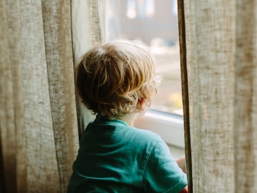 A toddler photographed from the back, between linen curtains. Kids sometimes need advocates outside ...