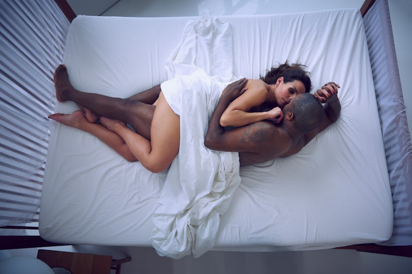 A couple in bed showing that sex shouldn't diminish when you get older — but sex positions should ch...
