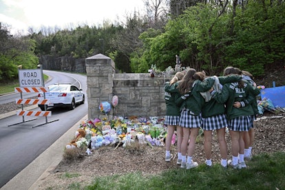 Girls embrace in front of a makeshift memorial for victims by the Covenant School, in a story about ...
