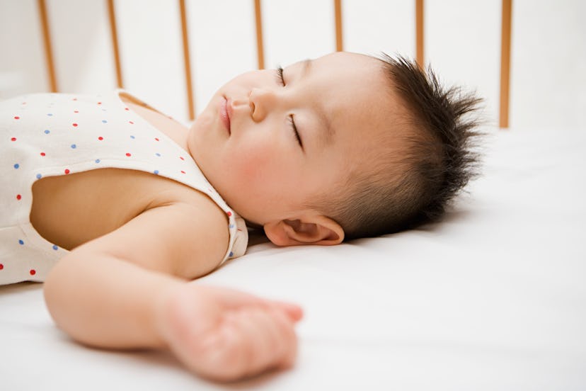 baby sleeping in crib in article about helping baby adjust to spring forward daylight saving time