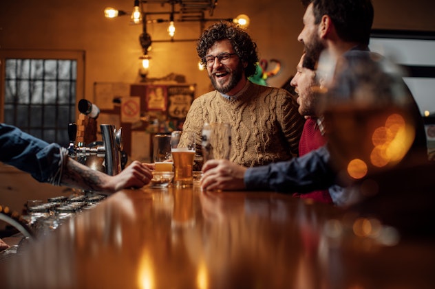 Group of male friends drinking beer at the pub together, in a list of St. Patrick's Day games