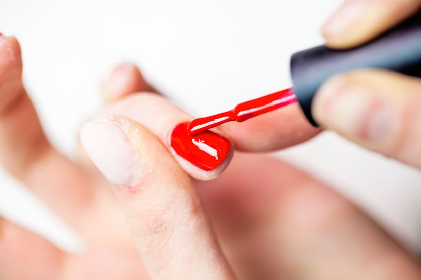 Red gel nail polish being painted on nails