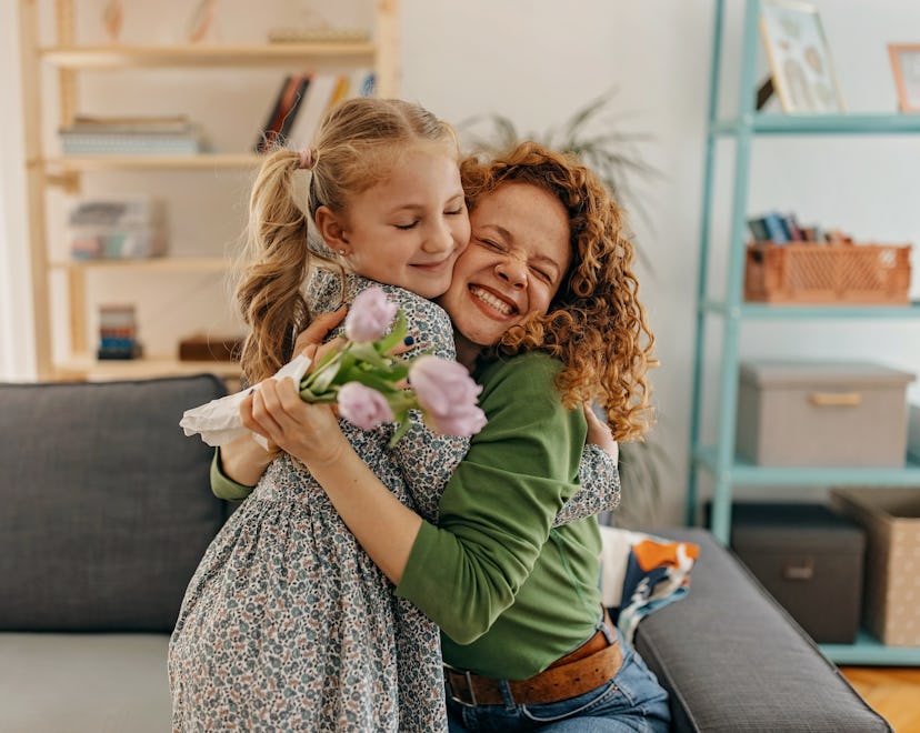 Daughter gives her mother a hug and a bouquet, in a story answering the question when is Mother's Da...