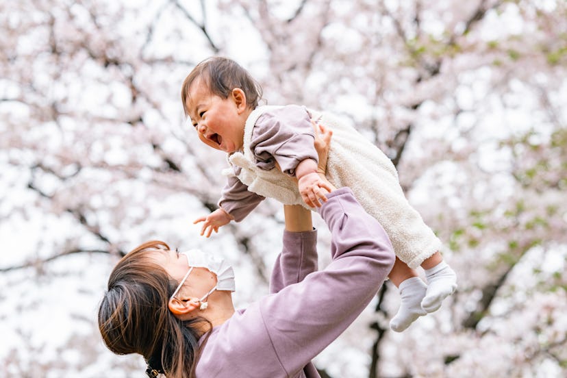 photo of mother and baby daughter enjoying cherry blossoms in article about names for babies born in...