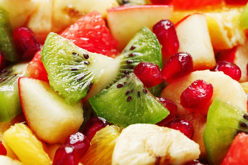 Fruit salad close-up in full screen, as a background. Slices of fresh and healthy fruits for a healt...