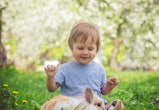 Happy child playing with bunny in article about baby names that mean lucky 